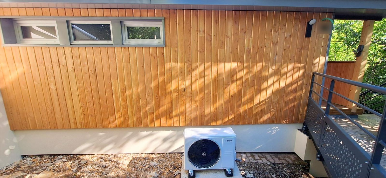 Unité extérieure de pompe à chaleur air/air installée sur un chalet dans le Jura